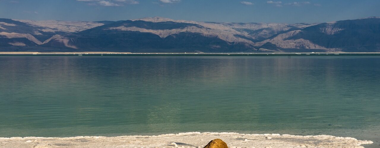 Salzstrand mit Meer und Gebirge im Hintergrund