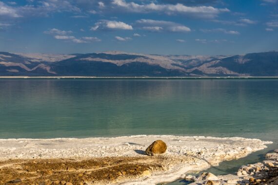 Salzstrand mit Meer und Gebirge im Hintergrund